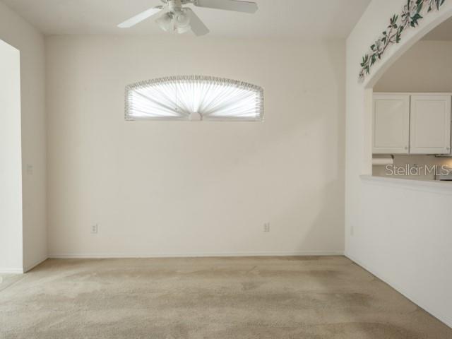 6 Summer Terrace, Unit 6 Palm Coast, FL 32137 - Photo 15 of 30 an empty room with a chandelier fan and kitchen view