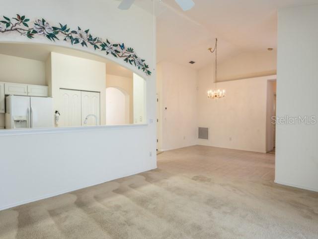 6 Summer Terrace, Unit 6 Palm Coast, FL 32137 - Photo 16 of 30 an empty room with a chandelier fan and wooden floor