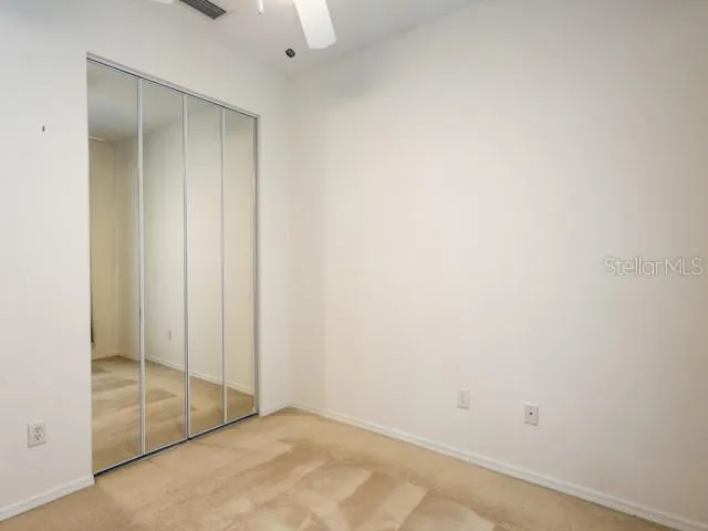 an empty room with a window and a fan