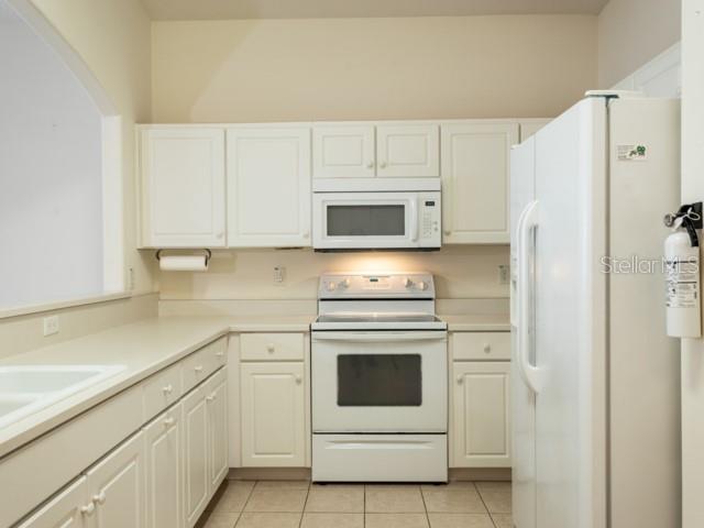 6 Summer Terrace, Unit 6 Palm Coast, FL 32137 - Photo 7 of 30 a kitchen with white cabinets and white appliances