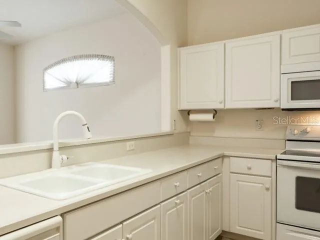 a kitchen with a sink cabinets and appliances