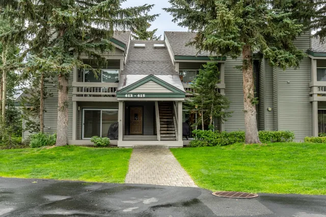 a front view of a house with a yard and trees
