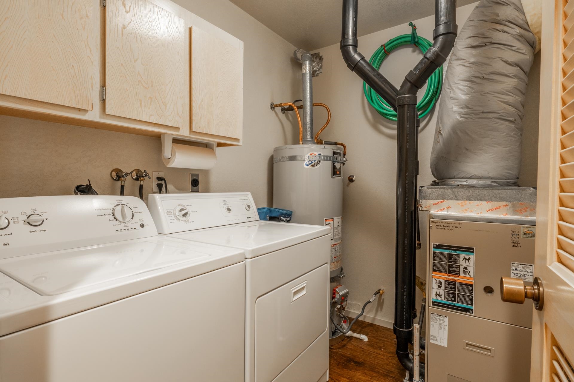 613 Golden Creek Road, Unit 613 Mammoth Lakes, CA 93546 - Photo 19 of 24 Washroom with cabinet space, dark wood finished floors, secured water heater, heating unit, and independent washer and dryer