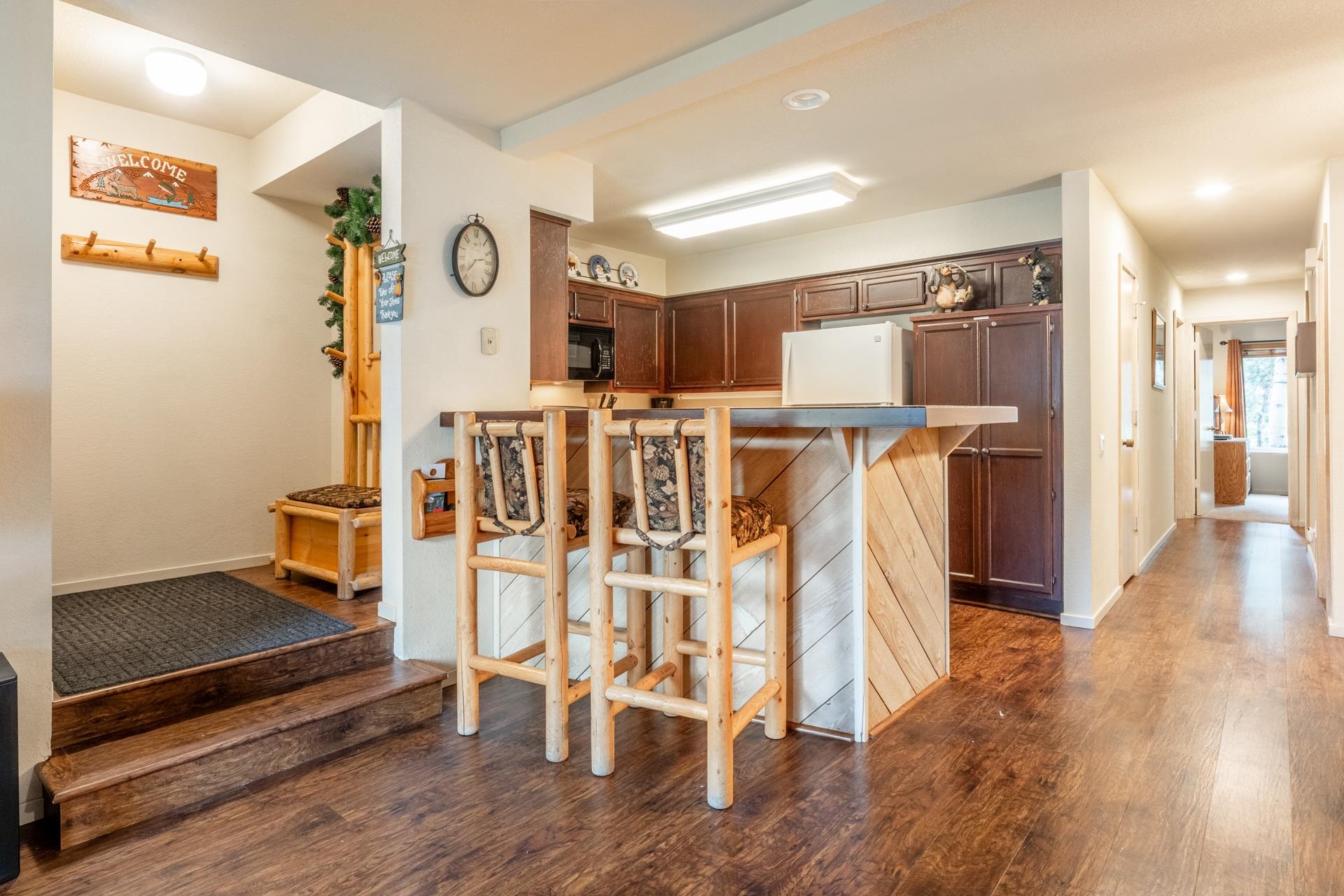 613 Golden Creek Road, Unit 613 Mammoth Lakes, CA 93546 - Photo 8 of 24 Kitchen featuring a kitchen bar, dark wood-style floors, a peninsula, freestanding refrigerator, and brown cabinetry