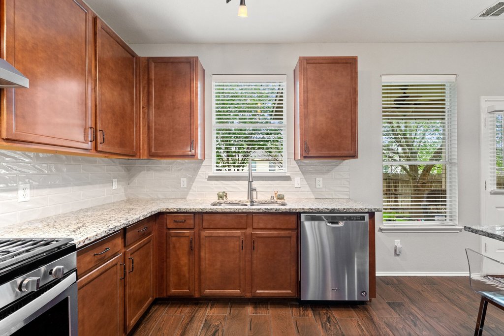 140 Wolfberry Path Buda, TX 78610 - Photo 11 of 35 a kitchen with a sink and cabinets