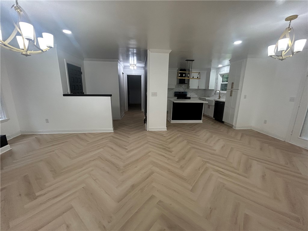 809 Paige Road Honea Path, SC 29654 - Photo 11 of 27 Herringbone pattern flooring seamlessly connects the open-concept living area to a modern kitchen.