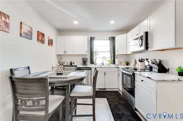a kitchen with a sink stove and white cabinets