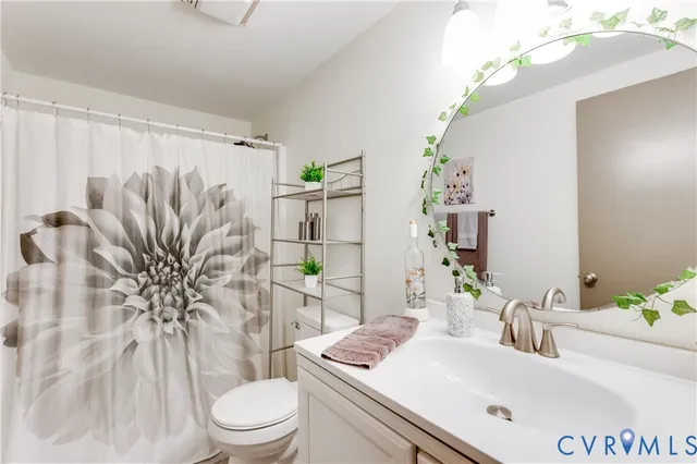 a bath room with a sink a toilet and a mirror