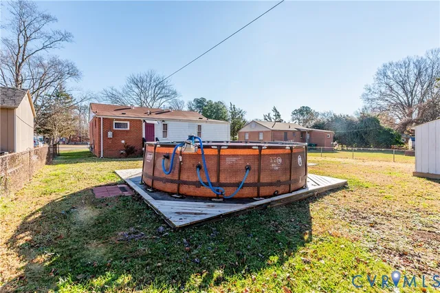 an aerial view of a house with yard and swimming pool
