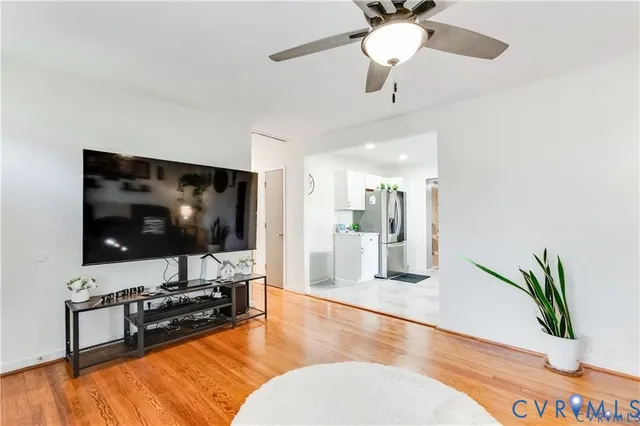 a kitchen with stainless steel appliances granite countertop a sink dishwasher stove and white cabinets with wooden floor