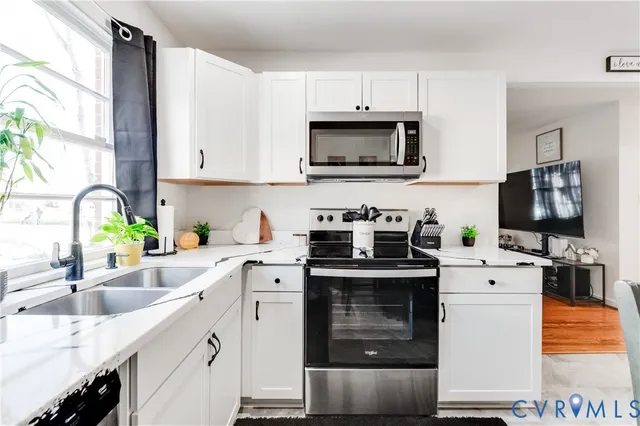 a kitchen with a sink stove and white cabinets