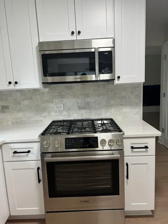 a stove top oven sitting inside of a kitchen