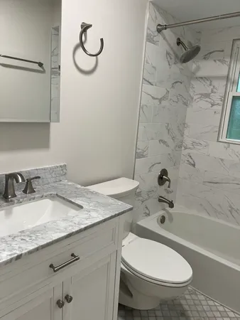 a bathroom with a granite countertop sink toilet and shower