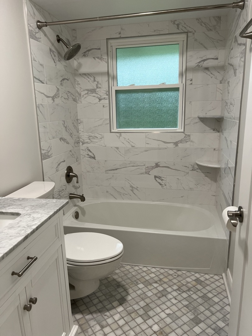 1106 Waukegan Road Deerfield, IL 60015 - Photo 13 of 29 a bathroom with a granite countertop bathtub shower sink vanity and toilet