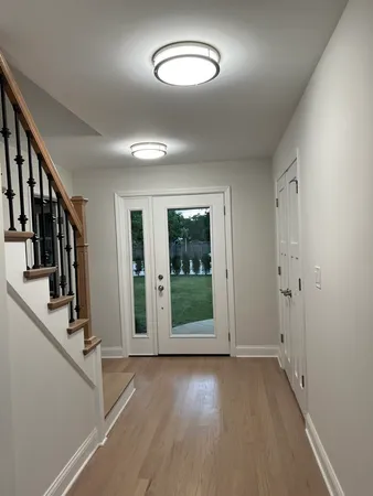 a view of a hallway with wooden floor and stairs