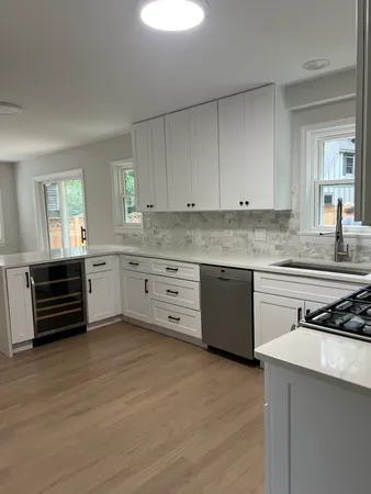 a kitchen with stainless steel appliances a stove a sink and white cabinets