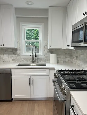 a kitchen with granite countertop a stove sink and microwave