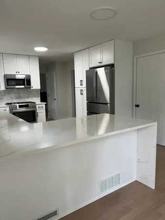 a kitchen with stainless steel appliances a refrigerator and a stove top oven
