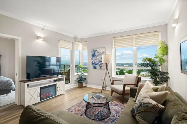 a living room with furniture a flat screen tv and a large window