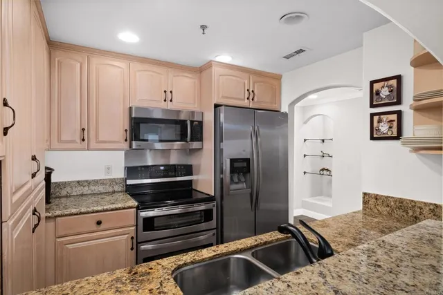 a kitchen with stainless steel appliances granite countertop a refrigerator and a sink