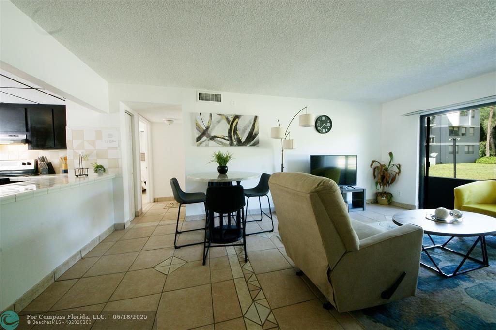 1920 North Congress Avenue, Unit 105 West Palm Beach, FL 33401 - Photo 2 of 19 a living room with furniture and a flat screen tv
