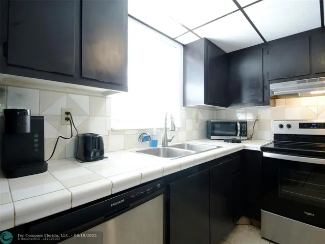 a kitchen with counter top space cabinets and stainless steel appliances
