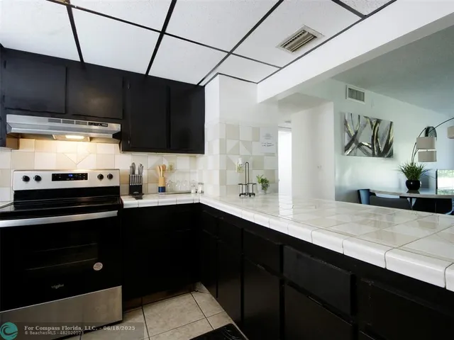 a kitchen with stainless steel appliances a sink dishwasher a stove and cabinets