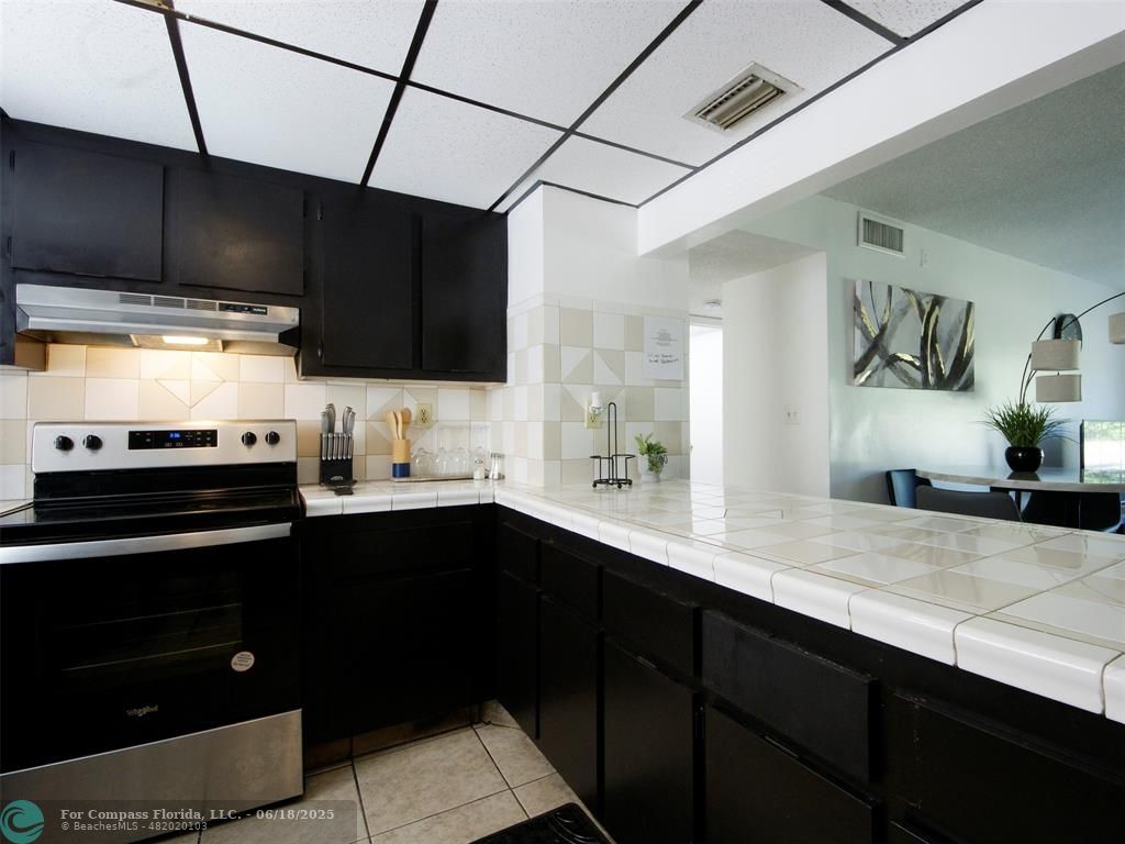 1920 North Congress Avenue, Unit 105 West Palm Beach, FL 33401 - Photo 6 of 19 a kitchen with stainless steel appliances a sink dishwasher a stove and cabinets