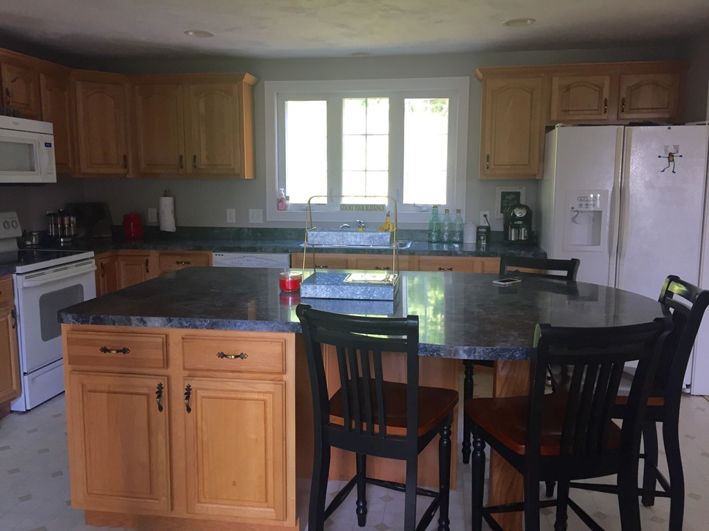 3 Eastern Lane Rutland, MA 01543 - Photo 2 of 22 a kitchen with granite countertop a table chairs stove and refrigerator