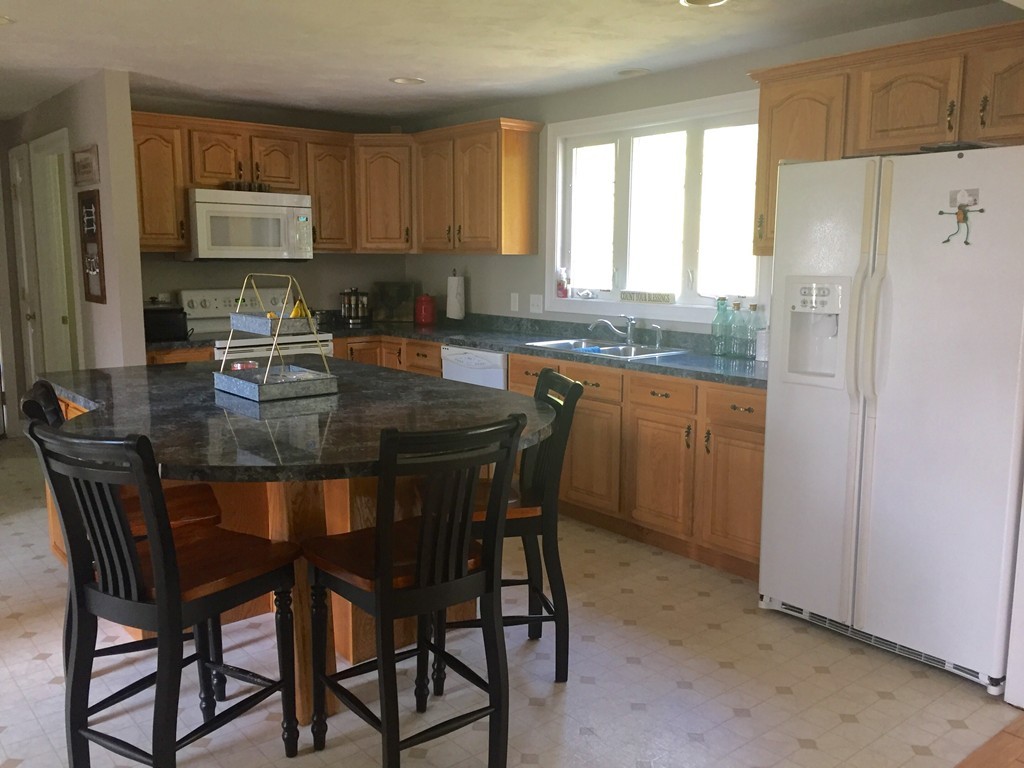 3 Eastern Lane Rutland, MA 01543 - Photo 3 of 22 a kitchen with a table chairs refrigerator and window
