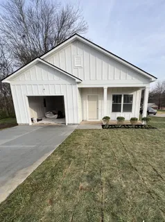 a view of a house with backyard and chairs