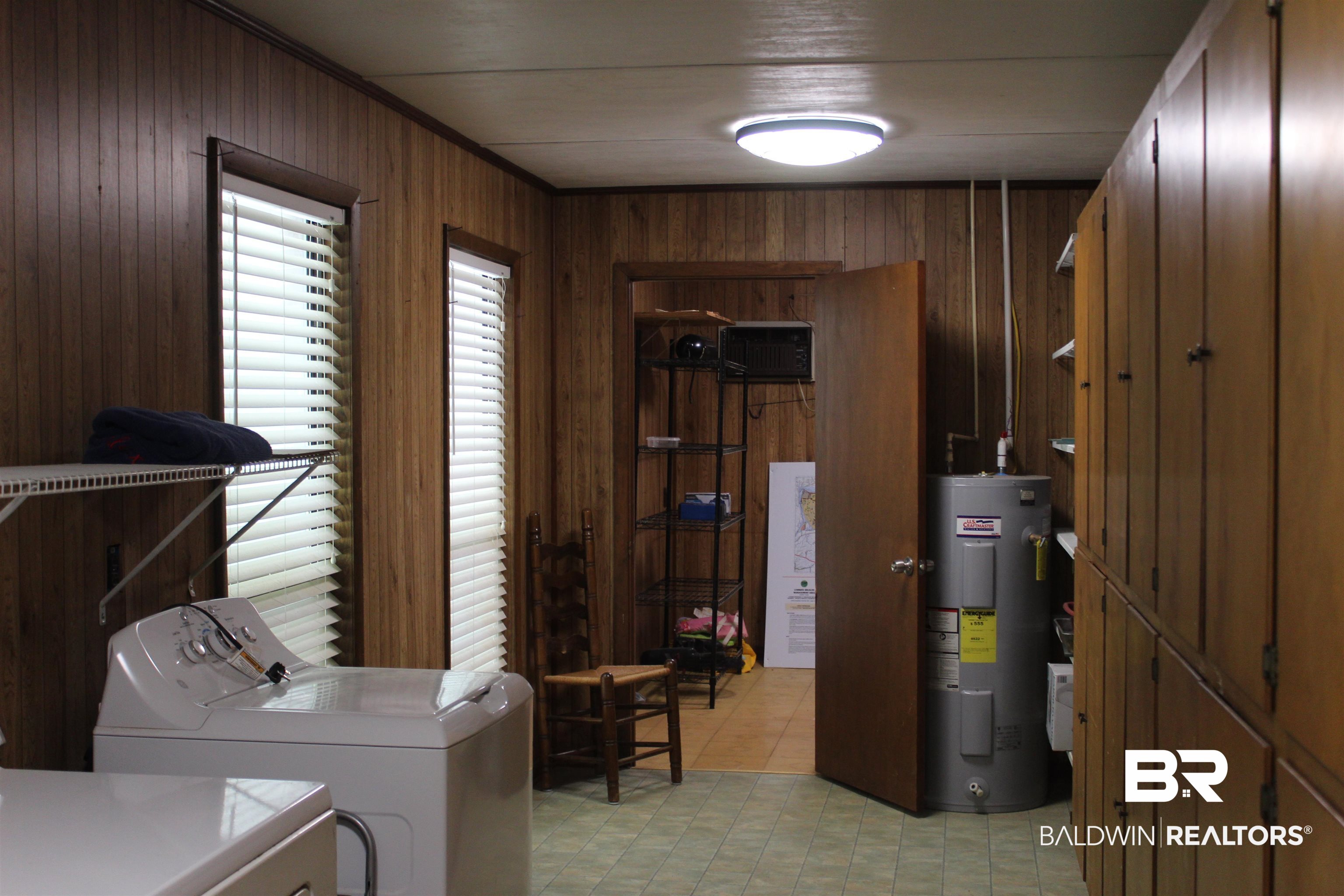 6447 Henderson Road Lowndesboro, AL 36752 - Photo 20 of 22 Laundry room featuring water heater, wooden walls, and separate washer and dryer