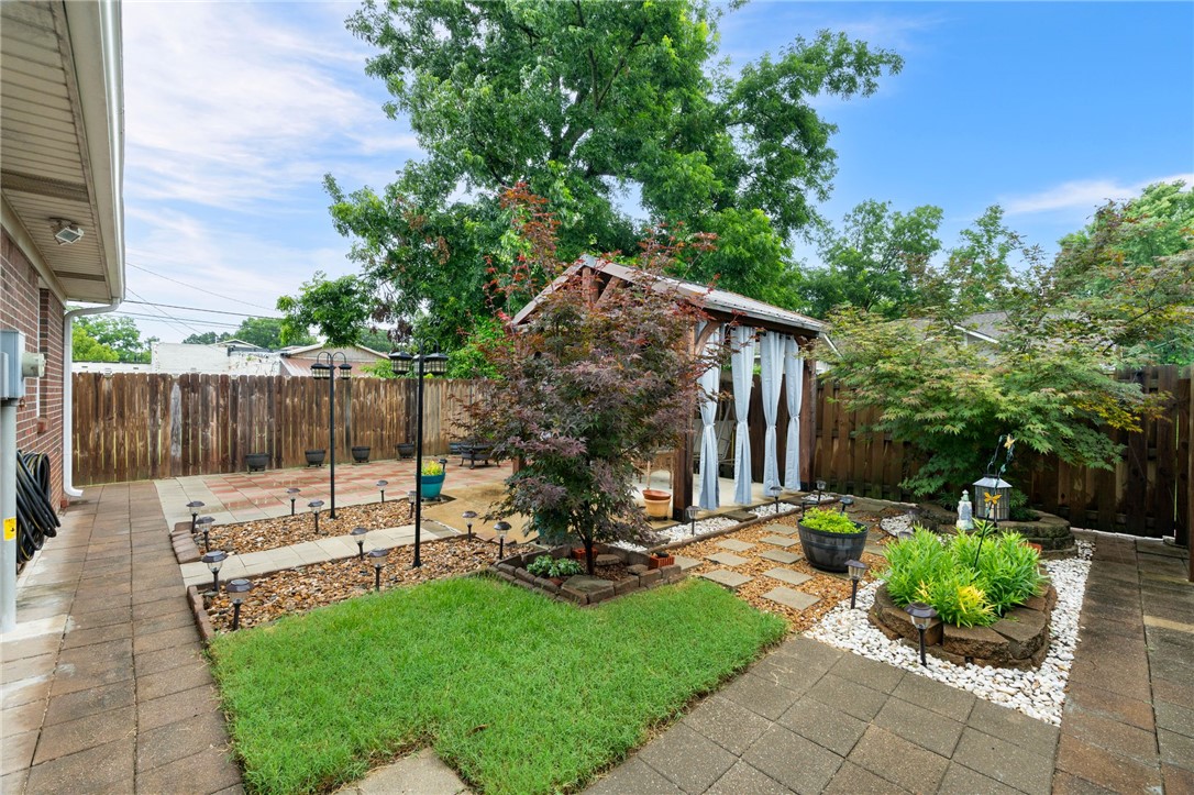 624 Locke Street Alma, AR 72921 - Photo 31 of 32 Enclosed backyard featuring a privacy fence, wood pergola with drapes, and a paved patio