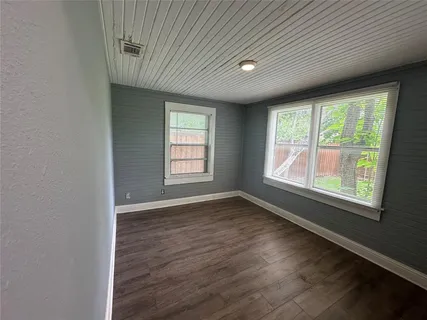 an empty room with wooden floor and closet