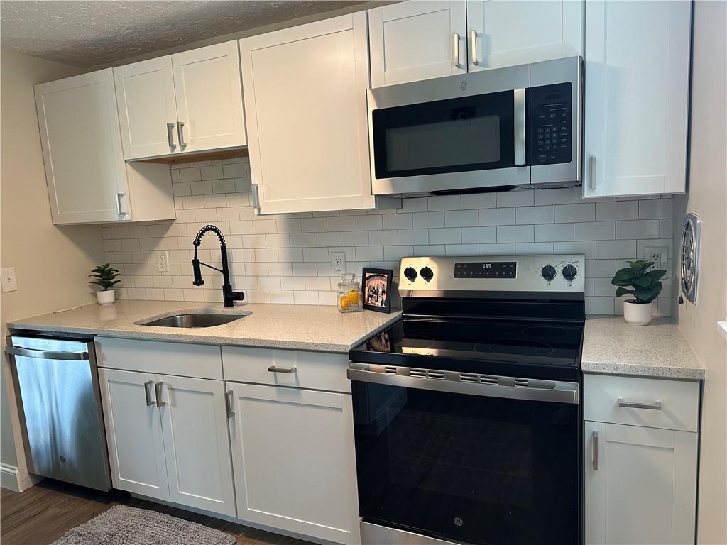 60 Greenleaf Drive Cheswick, PA 15024 - Photo 11 of 29 a kitchen with stainless steel appliances granite countertop white cabinets a microwave a stove and a sink