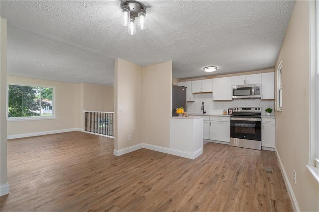 60 Greenleaf Drive Cheswick, PA 15024 - Photo 9 of 29 a kitchen with granite countertop a stove a sink and a refrigerator