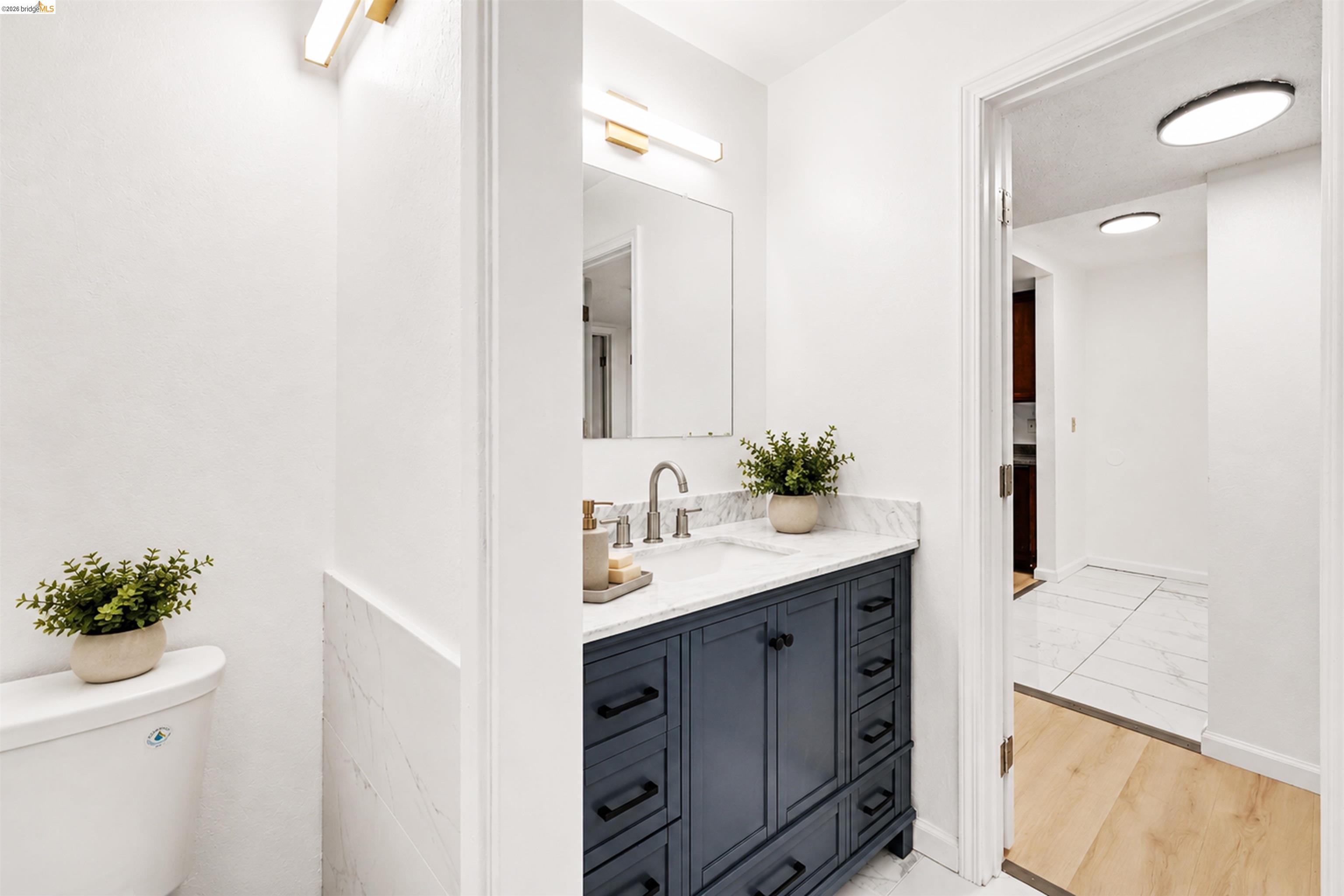 4186 San Pablo Dam Road, Unit A El Sobrante, CA 94803 - Photo 14 of 34 Bathroom vanity featuring a vessel sink, a marble-finish countertop, and a dark blue base with cabinet and drawer storage