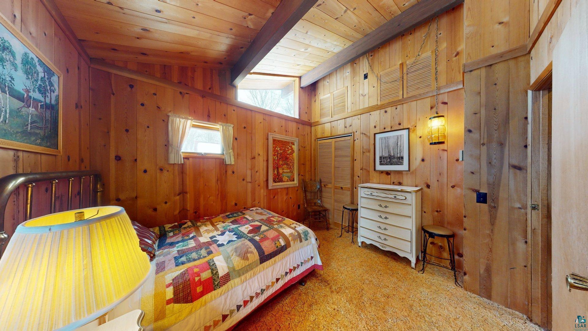 4512 Krollman Road Orr, MN 55771 - Photo 24 of 38 Carpeted bedroom featuring wood ceiling, wood walls, and lofted ceiling with beams