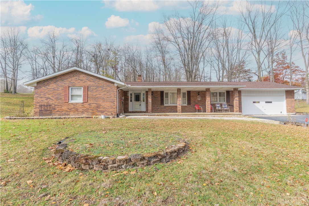 18333 Lefevre Number 2 Road Sidney, OH 45365 - Photo 2 of 25 This classic brick residence features a welcoming covered porch, an attached garage, and a spacious front yard.