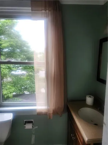 a bathroom with a sink a toilet and a window