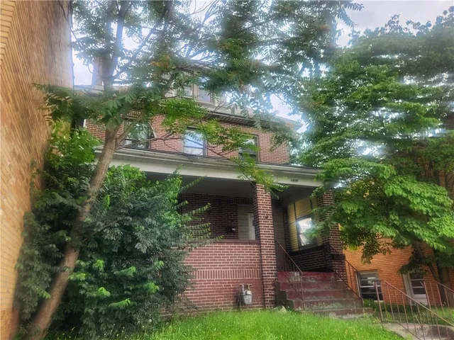 a view of a house with a tree in front of it