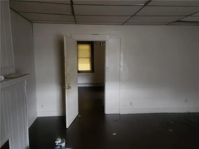 a view of a hallway with wooden floor and cabinet