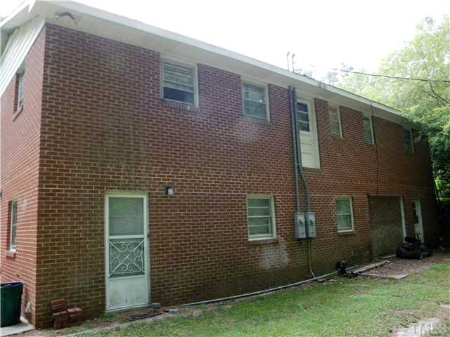1426 Trinity Circle Raleigh, NC 27607 - Photo 6 of 12 Rear photo of house. Needs a new garage door. The owner wanted to build a deck on the upper main level and never did build the deck that is why the door is built on the second floor.