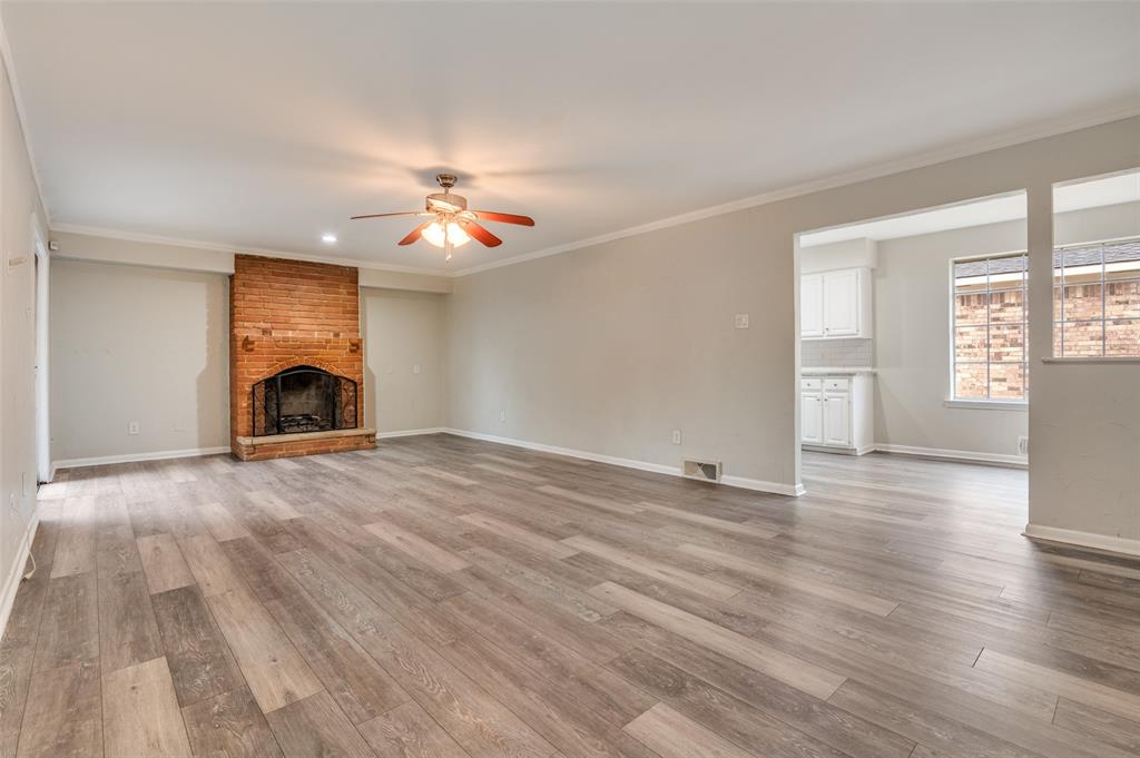 2244 Homeway Circle Dallas, TX 75228 - Photo 4 of 12 Unfurnished living room featuring a fireplace, ornamental molding, light wood-style floors, and a ceiling fan