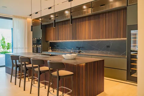 a kitchen with a sink and chairs