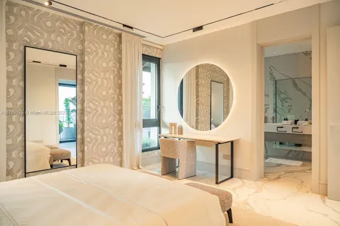 a bedroom with a bed a mirror and a table in it