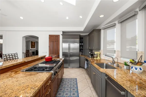 a kitchen with kitchen island granite countertop a sink stove and refrigerator