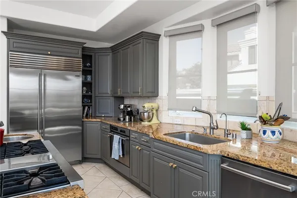 a kitchen with stainless steel appliances granite countertop a stove a sink and a refrigerator