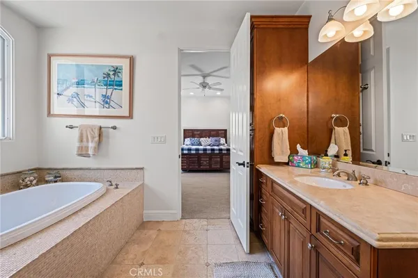a bedroom with a bed a desk and chair with a potted plant