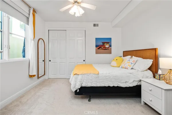 a spacious bedroom with a bed and a dresser